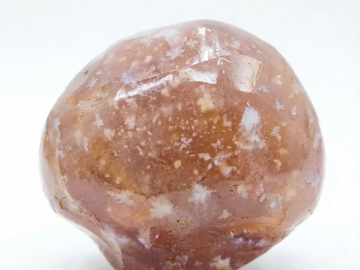 Polished cherry blossom agate showing cream, peach, and pink flower-like inclusions